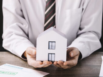 crop-man-holding-paper-house